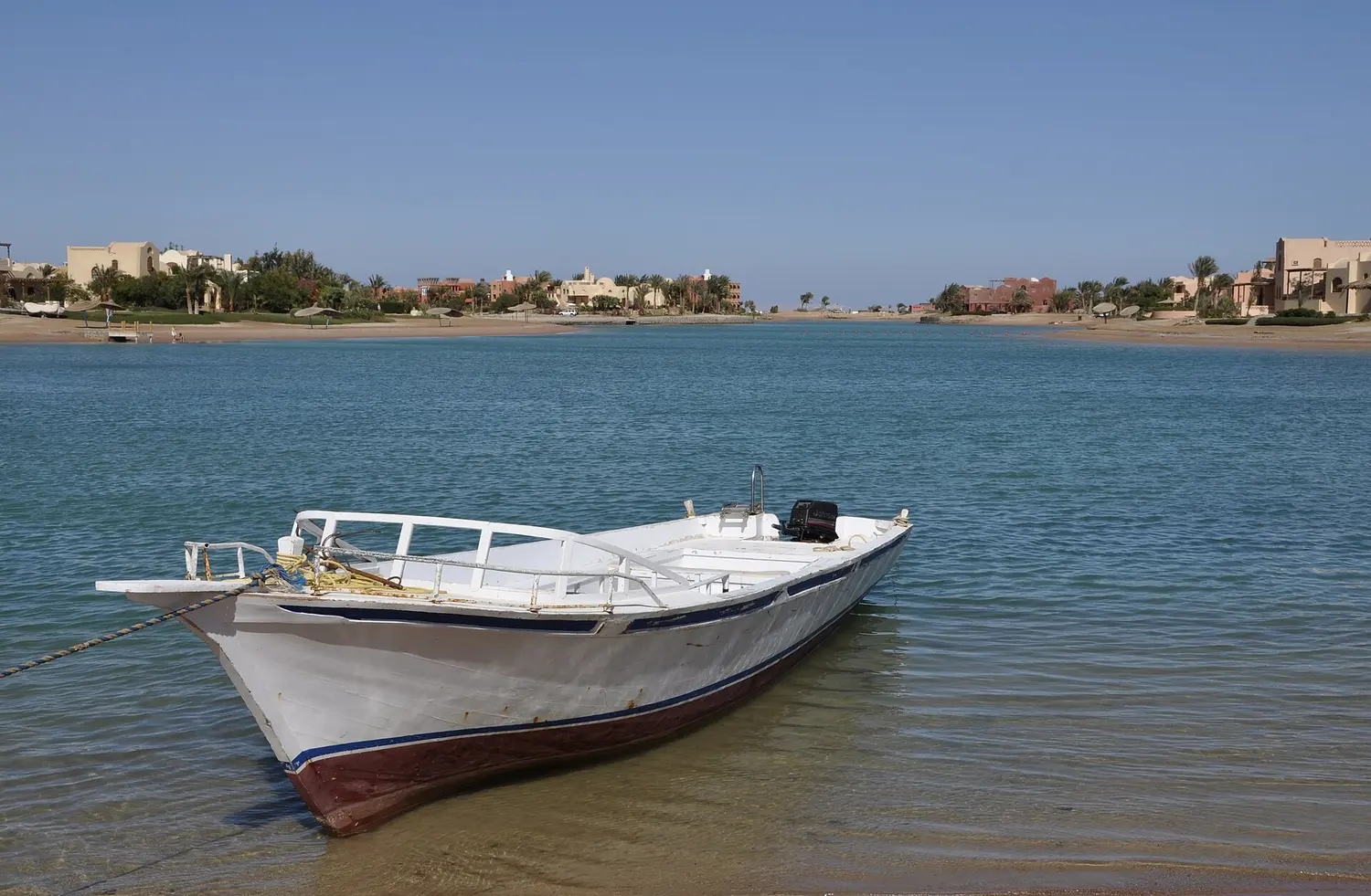 A small white boat on the calm El Gouna lagoon