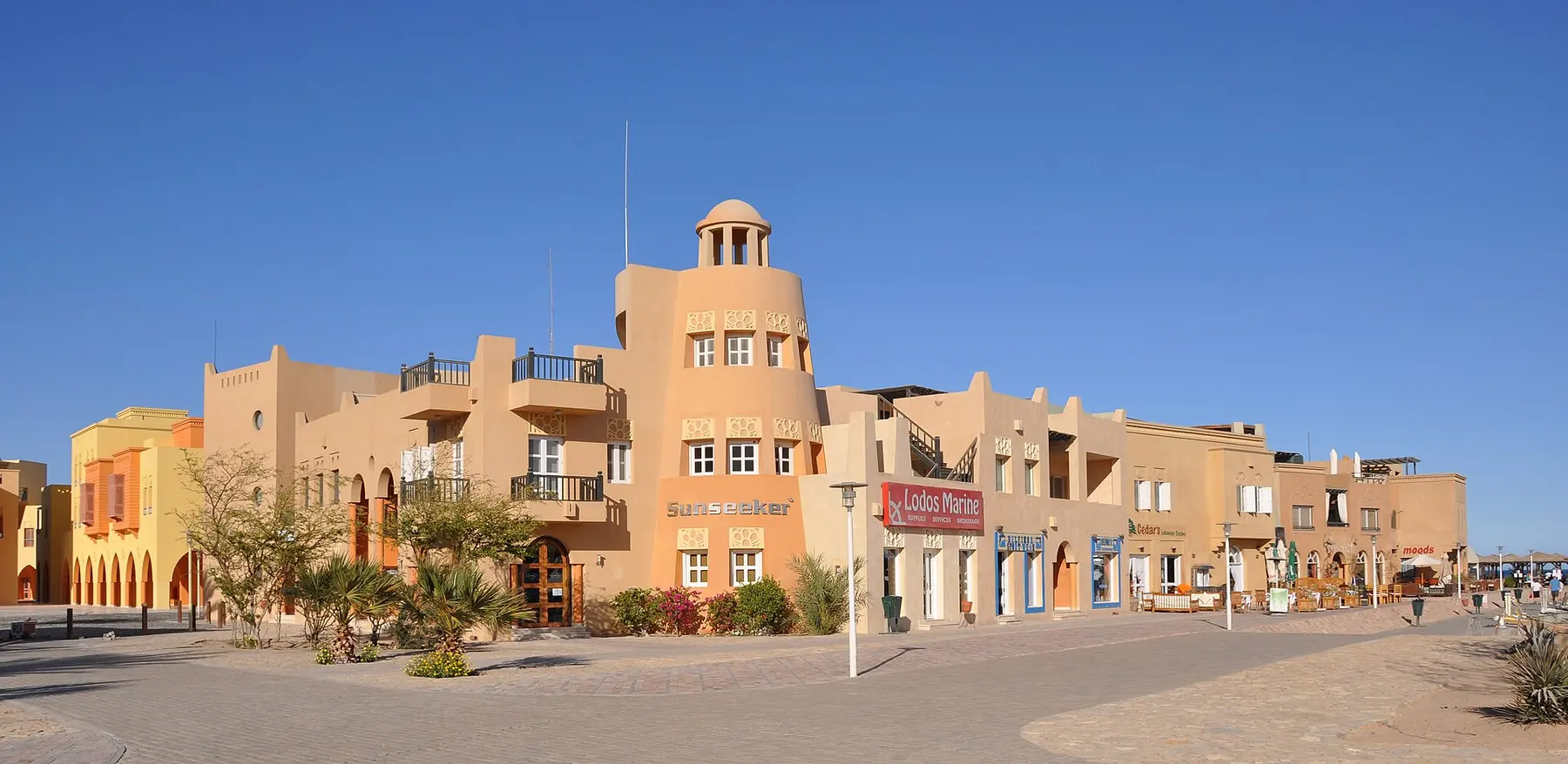 Sand-coloured buildings and palms along a street in El Gouna